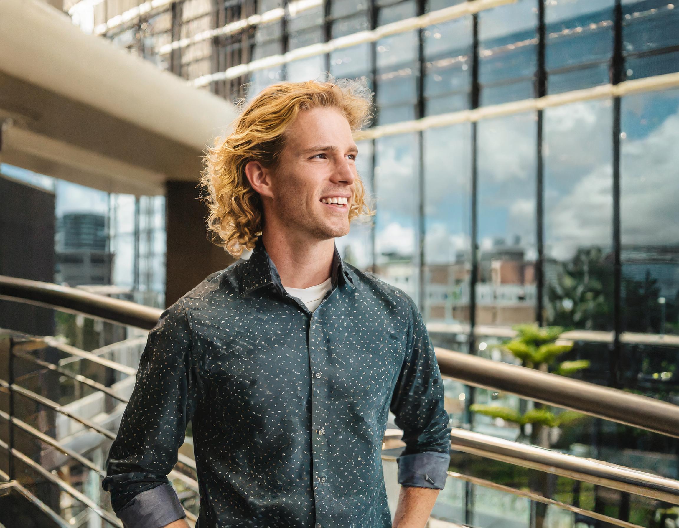 Männlicher Teammitglied mit freundlichem Gesichtsausdruck in modernem Büro